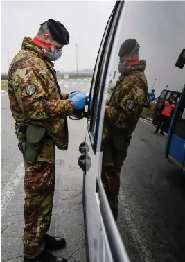  ??  ?? Italian Army soldiers check transit to and from the cordoned areas near Turano Lodigiano, Northern Italy.