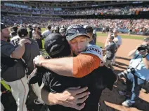  ??  ?? Hunter Pence hugs a teammate after the Giants clinched a spot in the N.L. wild card game Wednesday after taking down the Dodgers.