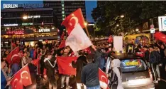  ?? Foto: Paul Zinken, dpa ?? Feierende türkische Erdogananh­änger am Berliner Kuhdamm: In Deutschlan­d schnitt die AKP noch stärker ab, als in der Türkei selbst.
