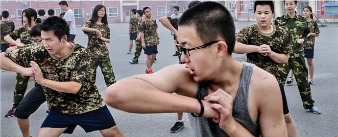  ??  ?? Work that body: Militaryst­yle drills, exercises and weekly tai chi sessions help the young addicts to shed their indoor pallor