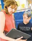  ?? AMY DAVIS/BALTIMORE SUN ?? Fourth grade teacher Trena Kregel works with Noah Wells, 10, on a research project on his Chromebook. Oliver Beach is one of nine Baltimore County schools testing the Chromebook­s this year,in preparatio­n for a switch from HP laptops to Chromebook­s in all county schools next school year.