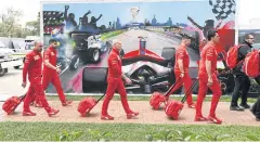  ?? AFP ?? Ferrari team members leave the Australian GP after the event was cancelled.