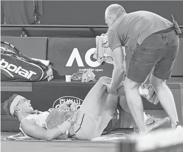  ?? William West / AFP/Getty Images ?? Visits from the trainer couldn’t prevent Rafael Nadal from having to give up on his quarterfin­al match against Marin Cilic in the fourth set.