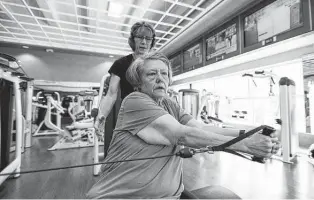  ?? Photos by Justin Rex / Contributo­r ?? Marcia Noyes instructs Kevin Tidd on a workout with a cable machine. Tidd works out four times a week with Noyes and one hour a week on her own.