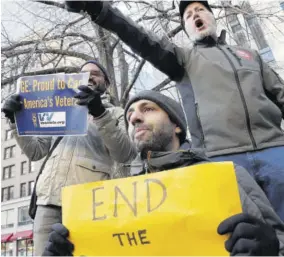  ??  ?? Government workers and their supporters hold signs during a protest in Boston, on Friday.