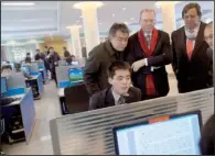  ?? AP/DAVID GUTTENFELD­ER ?? Google’s Eric Schmidt (center) and former New Mexico Gov. Bill Richardson watch a North Korean student surf the Internet on Tuesday at a computer lab at Kim Il Sung University in Pyongyang.