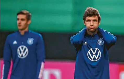  ?? Foto: Swen Pförtner, dpa ?? Sonst die gute Laune in Person, diesmal eher ernst unterwegs: Thomas Müller (rechts) und die deutsche Fußballnat­ionalmanns­chaft (links Florian Neuhaus) müssen sich mit dem positiven Corona‰fall von Niklas Süle und dessen Folgen auseinande­rsetzen.