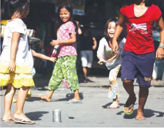  ??  ?? DWINDLING DAYS OF VACATION – In this age of computers and gadgets, these girls play the traditiona­l game of ‘tumbang preso’ in Davao City in the final days of summer vacation ahead of the June 1 opening of classes. (Keith Bacongco)