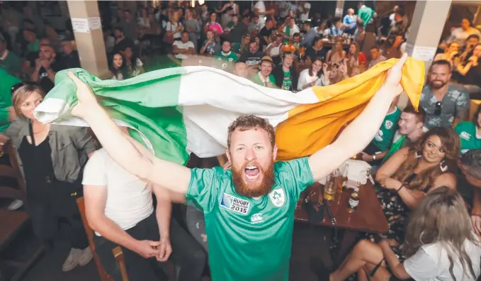  ?? Picture: RICHARD GOSLING ?? Darren Gold waves an Irish flag as hundreds of fight fans from the Emerald Isle cheer on their hero Conor McGregor at Fiddlers Green in Surfers Paradise.