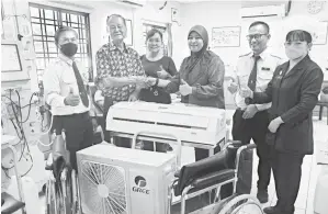  ?? ?? TERIMA KASIH: Ngui (dua kiri) dan isteri, Choon Ken bersalaman dengan Dr Nurain (tiga kanan) disaksikan Lijau (dua kanan) pada penyerahan alat pendingin hawa dan kerusi roda di Hospital Limbang semalam.