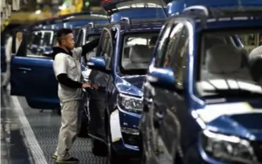  ??  ?? Workers examine cars on a production line of Dongfeng Liuzhou Motor Co. Ltd. in Liuzhou, Guangxi Zhuang Autonomous Region, on November 10, 2015