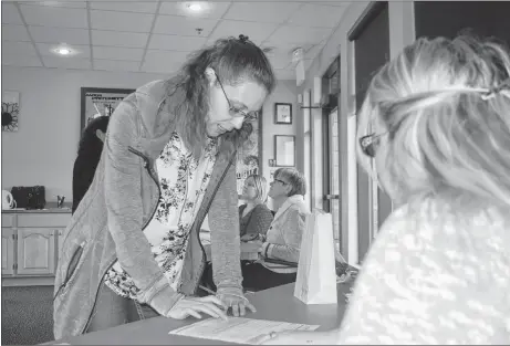  ?? KEVIN ADSHADE/THE NEWS ?? Volunteer Angie Degaust looks on as Dana Francis of Pictou Landing registers her daughter as a cancer survivor during an informatio­n session put on by Relay for Life organizers this week.