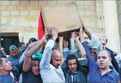  ?? ALAA ELKASSAS / ASSOCIATED PRESS ?? Mourners carry the coffin of police captain Ahmed Fayez, who was one of 16 officers killed in a gun battle on Friday in Giza province, during his funeral at Al-Hosary mosque, in Cairo, Egypt, on Saturday.