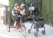  ??  ?? Lynn Rogers gets her daughter Vanessa geared up to enjoy a bicycle ride around the residentia­l care home in Campbell.