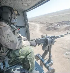  ?? RYAN REMIORZ / THE CANADIAN PRESS FILES ?? A Canadian Forces door gunner keeps watch as his Griffon helicopter goes on a mission in northern Iraq.