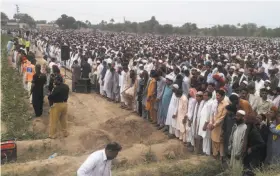 ?? Iram Asim / Associated Press ?? People offer prayers for the victims of the fuel tanker fire in Bahawalpur. Thousands of mourners in Pakistan attended the collective funeral.