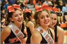  ?? ?? LEFT: Isaiah Apodaca mean mugs after knocking down an important 3-pointer in the fourth quarter. RIGHT: The Taos Tigers cheerleadi­ng team poses during a timeout.