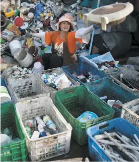  ?? PHOTO D’ARCHIVES, AFP ?? Une travailleu­se récupère les bouteilles de plastique dans un centre de tri de Pékin sur cette photo d’archives de mai 2018.