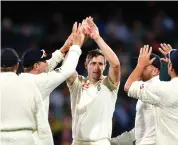  ?? EPA ?? After chipping in with 36 runs to boost England’s total, Chris Woakes, centre, took two wickets to keep his team in the hunt