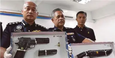  ?? [FOTO BERNAMA] ?? Fazlisyam (kiri) bersama Mohd Said (tengah) menunjukka­n senjata api dan parang yang ditemui pada Syukri pada sidang media di Ibu Pejabat Polis Daerah Kemaman, Chukai, semalam.