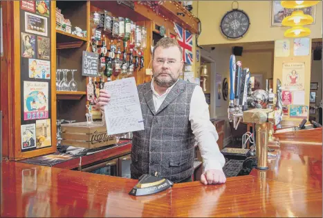  ?? Picture: Habibur Rahman ?? LEGAL BATTLE
Vladimir Nasadovich with what he says is the forged documents at his pub, the George and Dragon in North End