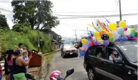  ??  ?? Los carros iban decorados con globos y mensajes para los escolares.