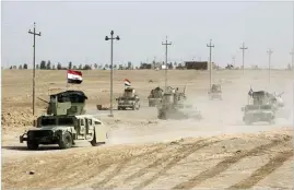  ??  ?? AHMAD AL-RUBAYE/AFP Iraqi forces and members of the Popular Mobilizati­on Units advance toward the city of Al-qaim in western Anbar Province on November 2, 2017.