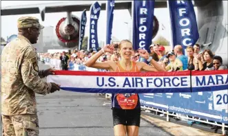  ?? DAVID JABLONSKI / STAFF ?? Women’s winner Ann Alyanak crosses the finish line at the Air Force Marathon last fall at WrightPatt­erson.