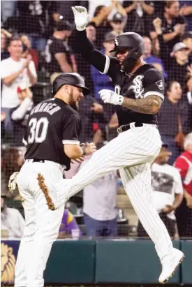 ?? NAM Y. HUH/AP ?? Yoan Moncada (right, with Jake Burger) celebrates after scoring during the Sox’ fiverun eighth inning Friday. He was 0-for-5 with three strikeouts Saturday.