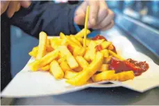  ?? FOTO:ARNO BURGI/DPA ?? Wer erst abends unbändige Lust auf Pommes oder anderes Fastfood bekommt, zählt eventuell zu den nachtaktiv­en Eulen.