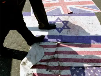  ??  ?? Des drapeaux britanniqu­e, israélien et américain sont placés sur le sol, dans une rue de Téhéran, pour être piétinés par les passants, en mai 2019.