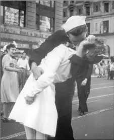  ?? VICTOR JORGENSEN/U.S. NAVy ?? In this Aug. 14, 1945, file photo provided by the U.S. Navy, a sailor and a woman kiss in New York’s Times Square, as people celebrate the end of World War II.