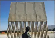  ?? AP/JAE C. HONG ?? A U.S. Border Patrol agent looks at one of border wall prototypes Thursday in San Diego.