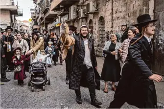  ?? Ohad Zwigenberg/Associated Press ?? Ultra-Orthodox Jews celebrate the festive holiday of Purim on Monday in Jerusalem. Many cities across Israel decided to cancel their Purim celebratio­ns due to the ongoing conflict in Gaza.