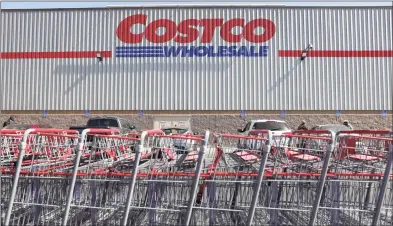 ?? Mario Tama / Getty Images ?? Shopping carts are lined up in front of a Costco store in Inglewood, Calif. Costco announced plans to increase its minimum wage to $16 per hour.