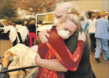  ?? Justin Sullivan Getty Images ?? HOSPITAL workers console each other as they evacuate patients from a hospital near Paradise, Calif., in advance of the Camp fire.