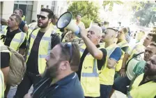  ??  ?? Des mineurs manifestan­t mercredi, à Athènes. − Associated Press: Petros Giannakour­is