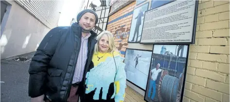  ?? JULIE JOCSAK/STANDARD STAFF ?? Julio Batres, chairman of the downtown Niagara Falls BIA, and Constance Cochrane are shown by a new memorial in Daredevil Alley for wirewalker Jay Cochrane, who died in 2013.