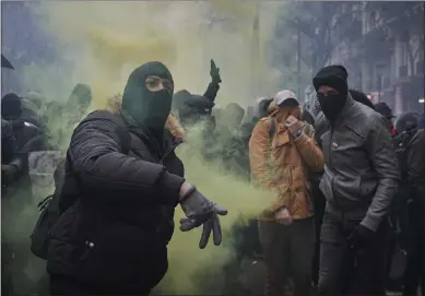  ??  ?? A protester throws a rock towards police during a rally near Place de Republique in support of the national strike