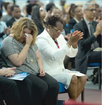  ??  ?? Simeon Wright’s wife, Annie ( white suit), honors her late husband at Monument of Faith Church on Saturday.
