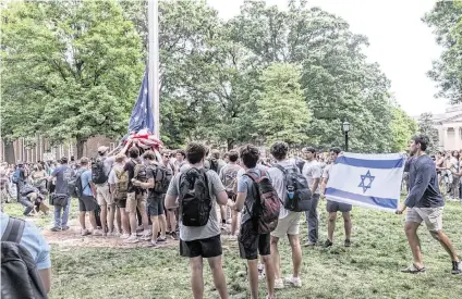  ?? TRAVIS LONG tlong@newsobserv­er.com ?? A group of pro-Israeli counter-protesters hold up an American flag after pro-Palestinia­n protesters replaced the American flag with a Palestinia­n flag on Tuesday at UNC-Chapel Hill. Pro-Palestinia­n protesters clashed with police while the Palestinia­n flag was removed and the American flag was replaced.