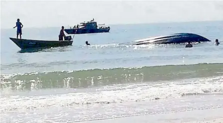  ??  ?? Tragedy at sea: Authoritie­s and fishermen helping to bring the capsized boat back to shore near Pantai Batu layar in Pengerang, Kota Tinggi.