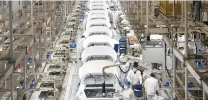  ?? AP ?? LESS DEPENDENT. Employees work on a car assembly line at the Dongfeng Honda Automobile Co., Ltd factory in Wuhan in central China’s Hubei province. The United States, Japan and France are persuading their companies to be less dependent on China for their production and raw material supplies. However, some companies are not convinced to leave the world’s biggest supplier of commoditie­s and skilled people due to its already establishe­d supply chain for any industry. /