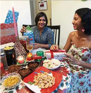  ??  ?? Ranita (right) and cousin Swetha Elisha wrap homemade cookies and cakes to present to their family and friends.