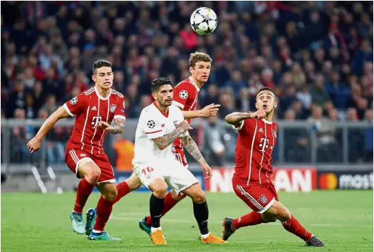  ?? — Reuters ?? Moving in fast: Bayern Munich’s Thiago Alcantara (right) in action against Sevilla’s Ever Banega (second from left) during the Champions League quarterfin­al second-leg match at the Allianz Arena on Wednesday.