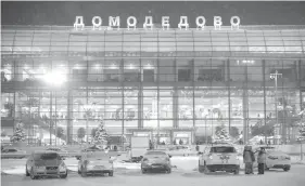  ?? AGENCE FRANCE PRESSE ?? Emergency personnel stand next to an emergency vehicle parked in front of the Domodedobo Internatio­nal Airport outside Moscow, as Russian passenger plane carrying 71 people crashed after taking off from this airport.