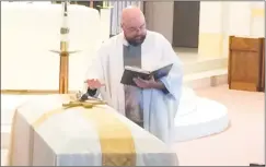  ?? Michael P. Mayko / Hearst Connecticu­t Media ?? The Rev. Jeffrey Gubbiotti prays over the casket of Ansonia Alderman Frank DeLibero.