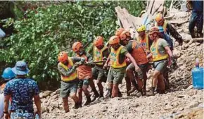  ?? EPA PIC ?? Rescue volunteers carrying the body of a landslide victim in Itogon town, Benguet Province, the Philippine­s, yesterday.