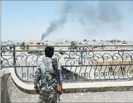  ?? GORAN TOMASEVIC / REUTERS / ARXIU ?? Combat a Al-Raqqa. Un milicià de la coalició internacio­nal contra l’EI observa un bombardeig sobre el feu islamista