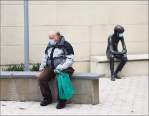  ?? Tyler Sizemore / Hearst Connecticu­t Media file photo ?? Greenwich's Earl Coyne wears a mask while waiting to pick up a book beside the beloved sculpture known as Andre, also wearing a mask, outside the Greenwich Library on Nov. 17, 2020.